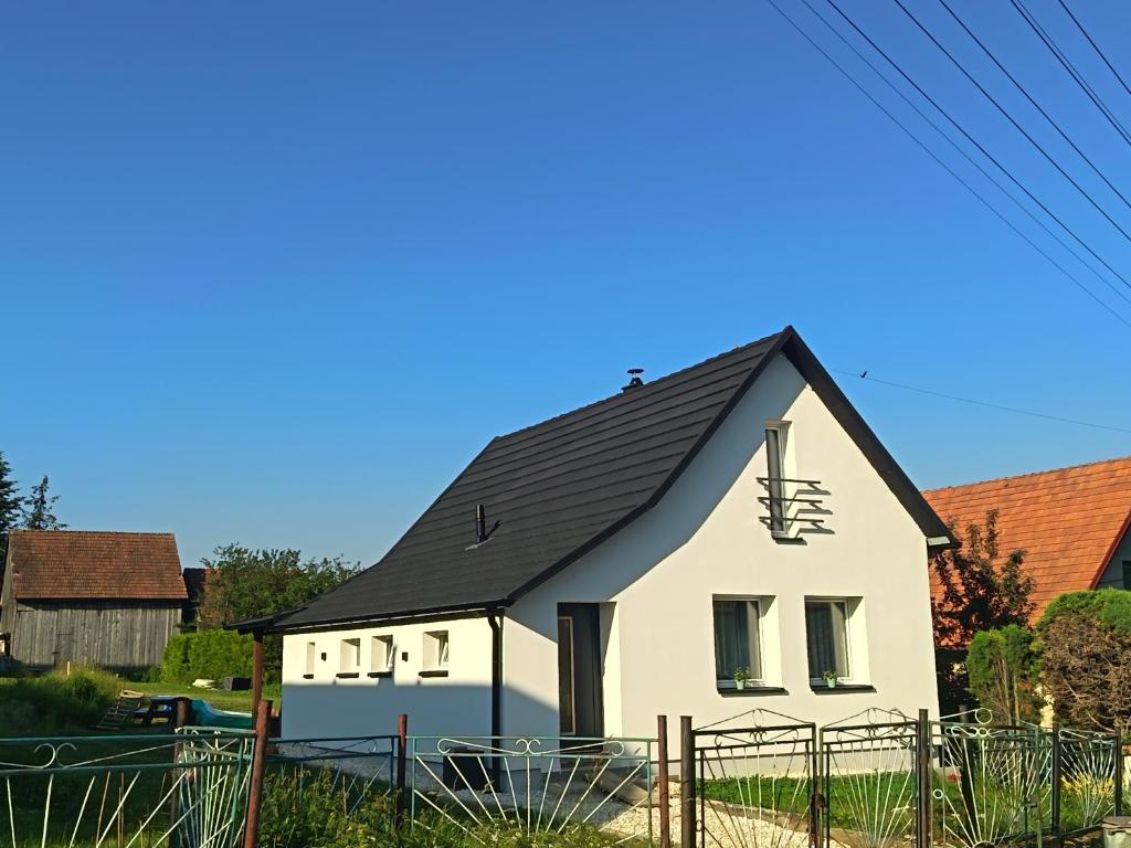 a small white house with a black roof at Domček u Alberta in Vrbov
