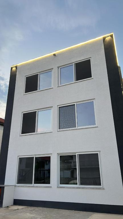 a white building with windows on the side of it at Apartmani Tajra in Donji Štoj