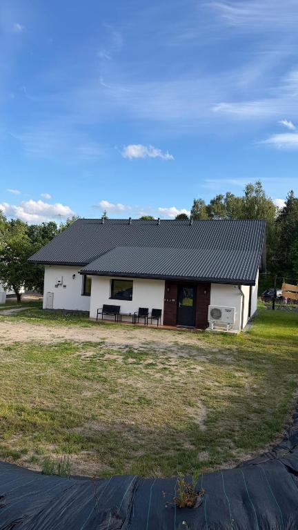 a white house with a black roof at Noclegi u Kozickich in Tomaszów Lubelski