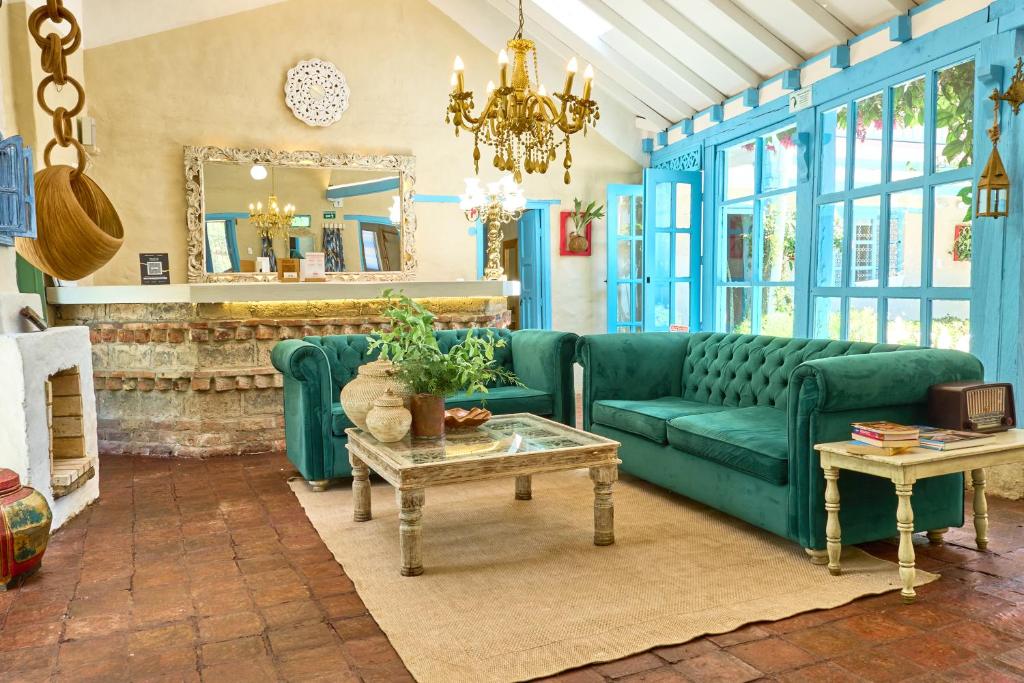 a living room with a green couch and a table at Casa Provenzal Hotel Boutique in Villa de Leyva