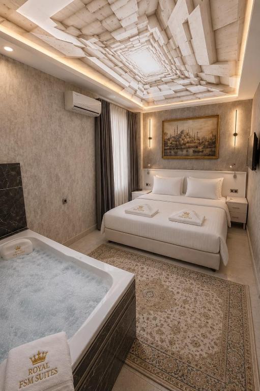 a bedroom with a large bed and a bath tub at Royal Fsm Suites in Istanbul