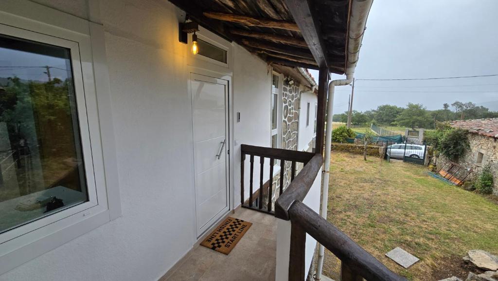 a door on the side of a house with a yard at Mirada Sacra in Parada del Sil