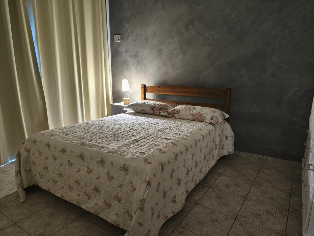 a bedroom with a bed with a white comforter at Casa Lyrata in Tatuí
