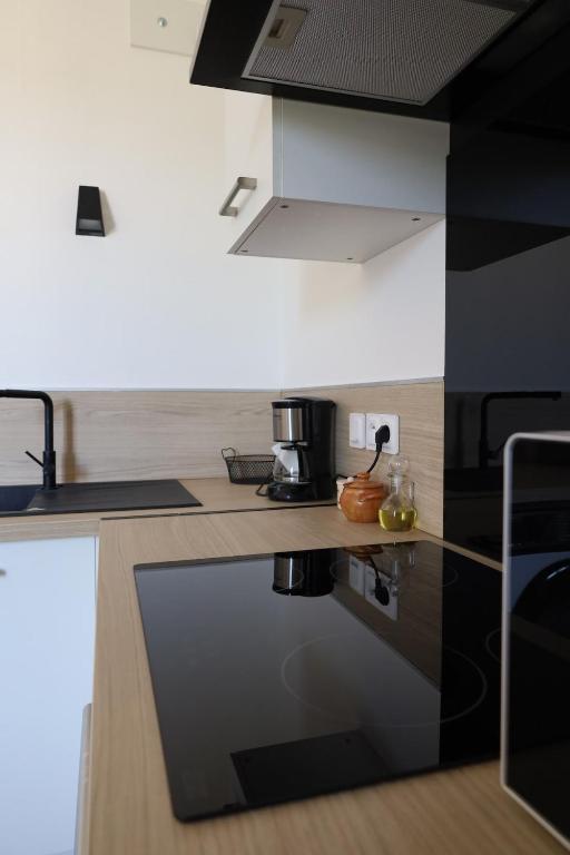 a kitchen with a black and white counter top at Appartement Cévenol in Le Vigan