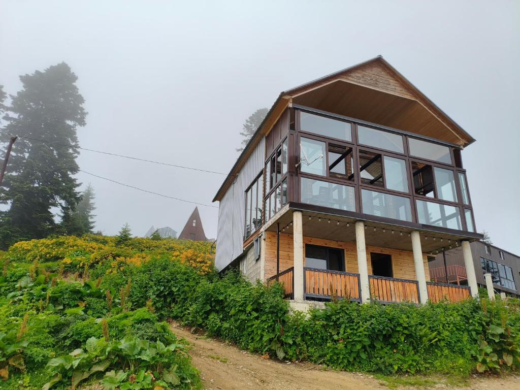 a house on top of a hill with glass at GomisMta-Luxury Cottage with Panor in Gomi