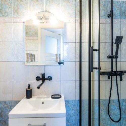 a bathroom with a sink and a shower at Pensjonat Koral in Kołobrzeg
