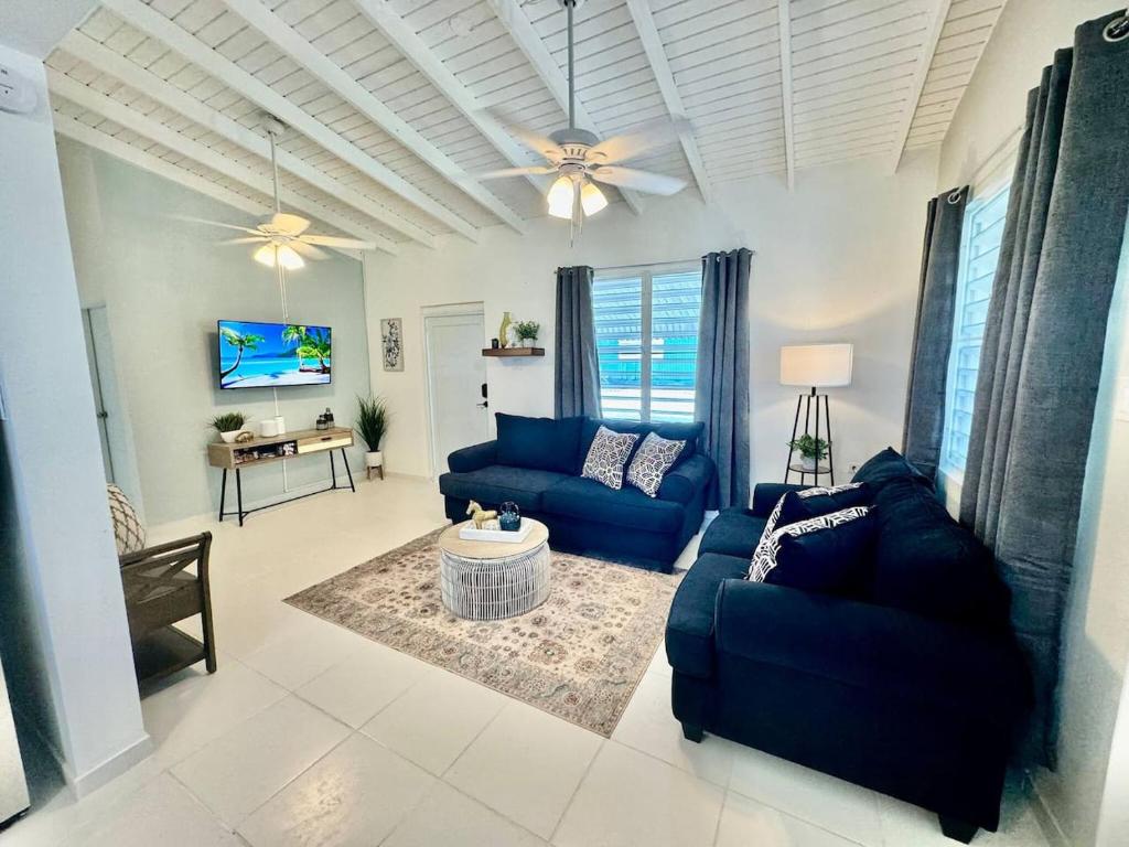 a living room with blue couches and a ceiling fan at Casa Playa in Boqueron