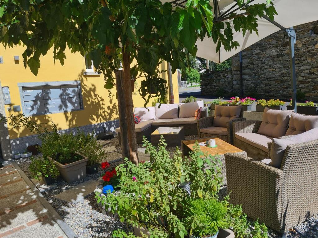 a patio with couches and a table and some plants at Ca' di Fant Malvaglia in Malvaglia