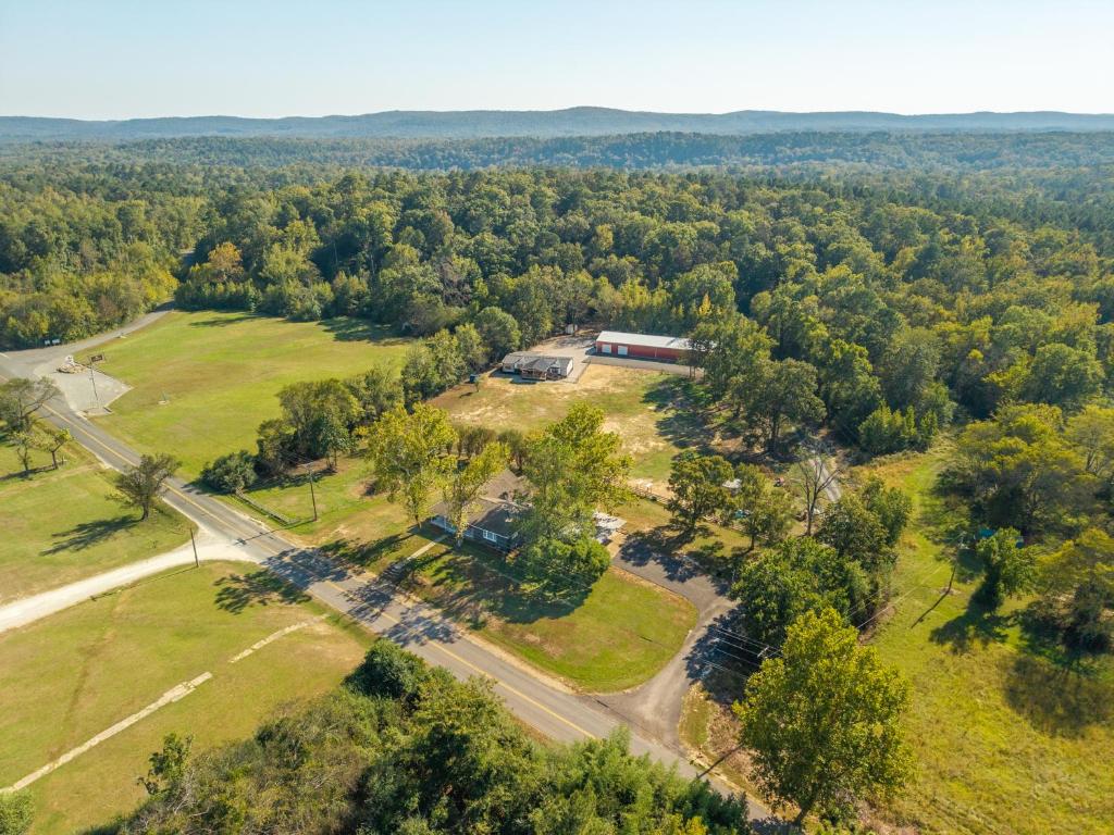 an aerial view of a building in a field with trees at Smallville Farm Retreat in Lake Catherine