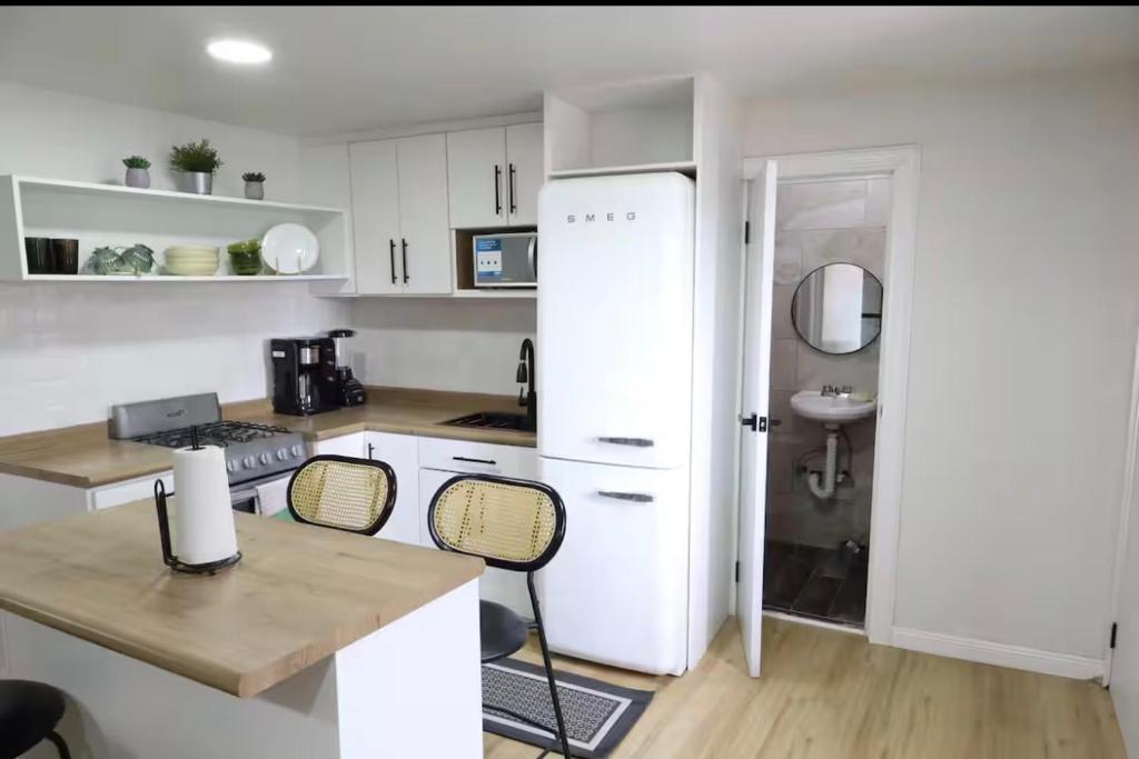 a kitchen with white cabinets and a white refrigerator at Bello loft studio en el corazón de Tijuana in Tijuana