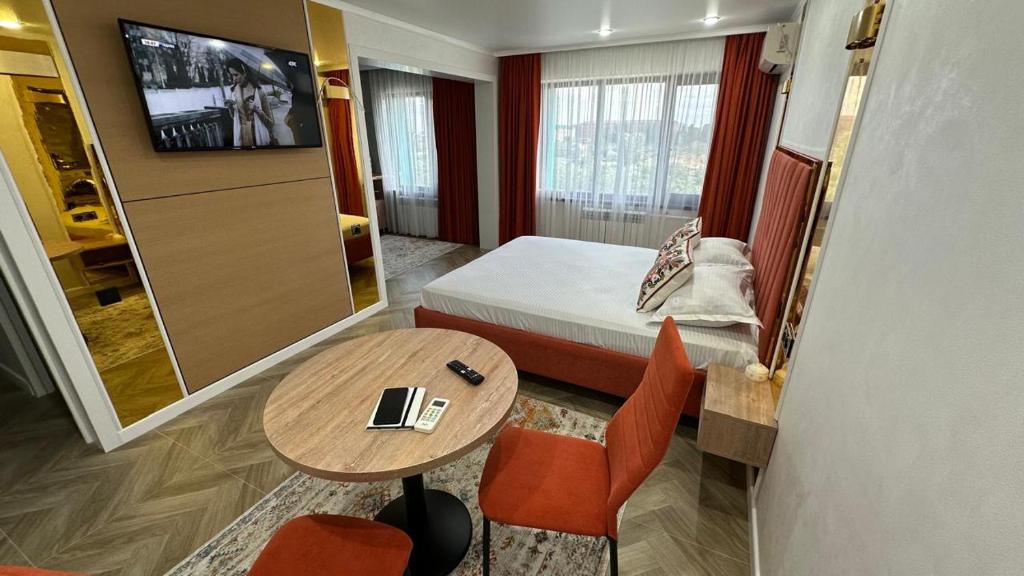 a small hotel room with a bed and a table and a table at Yuzhnaya in Qyzylorda