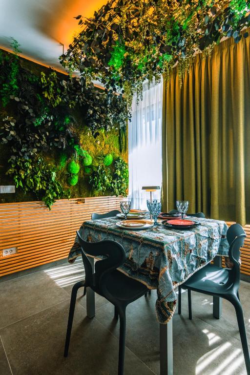 a dining room table with two chairs and a plant wall at Apartamento Yumbo Iguazu Luxury in Maspalomas