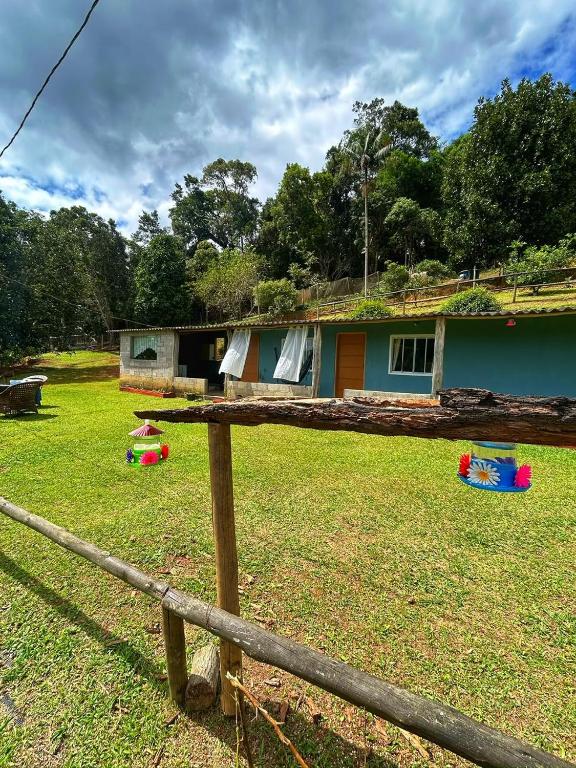 a house with a fence in front of a yard at Encanto da Paz in Miracatu