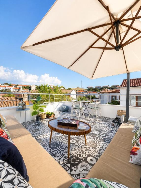 a patio with a table and an umbrella at Hil Ada 1 in Bozcaada