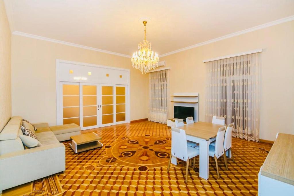 a living room with a table and a chandelier at 3 Bedrooms Apartment ın Center in Baku