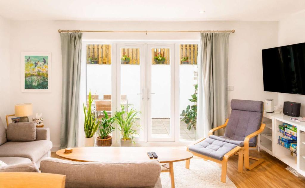 a living room with a couch and a table at Meadowvine - By Rowes Retreats in Penryn