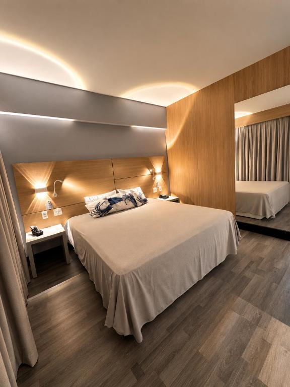 a hotel room with a large bed and two beds sidx sidx sidx sidx at Flat em Santos próximo a praia e Vila Belmiro in Santos