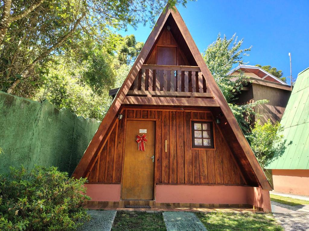 a small house with a door with a wreath on it at Chalé - Sossego 1 in Campos do Jordão
