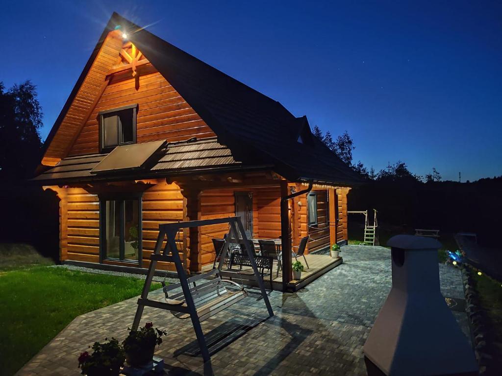 a log cabin with a table and chairs in front of it at Zdrojowe wzgórze in Rymanów-Zdrój