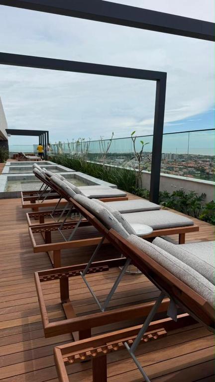 a row of lounge chairs on a deck with the ocean at Salinas Beach Resort in Salinópolis
