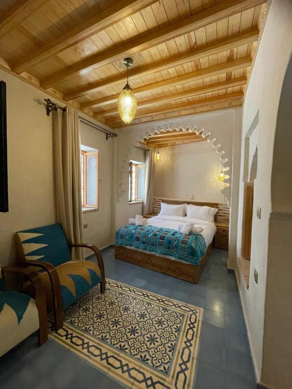 a bedroom with a bed and a chair in a room at Riad Nassar in Chefchaouen