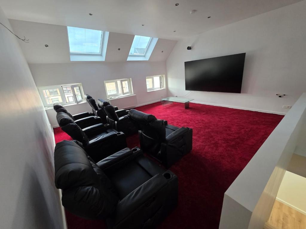 a large room with black chairs and a flat screen tv at Home cinema in Liège