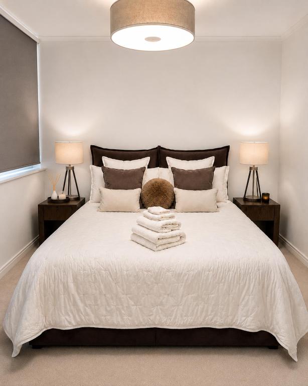 a bedroom with a large white bed with two lamps at Luxury Central Solihull Apt - King Bed, Sofa Bed & 2 Parking Spaces in Solihull