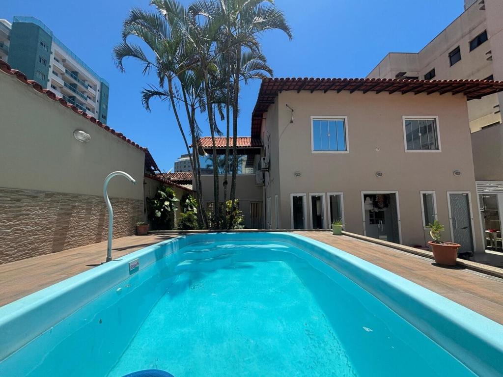 a swimming pool in front of a house at Casa Costa do Sol completa, 100m da praia in Macaé