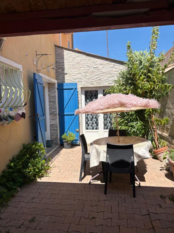 a table and chairs with an umbrella on a patio at Villa playa in Valras-Plage