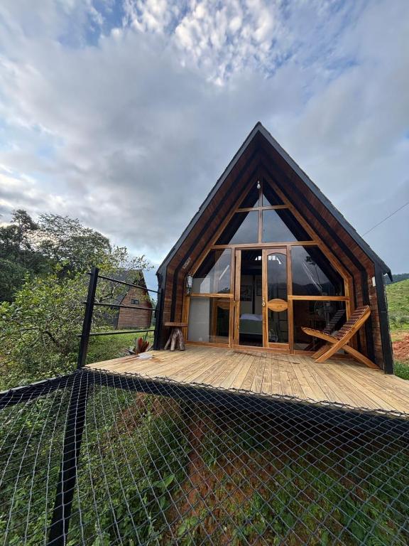 a cabin with a large window on a wooden deck at Ecolodge Ix Cacao in San Carlos