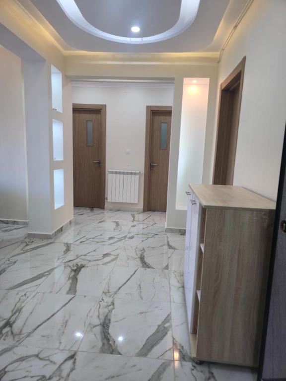 an empty room with marble floors and a ceiling at Apparemment valmascort annaba in Annaba