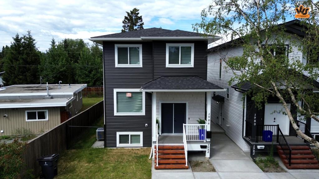 a black house with a porch and a driveway at The Ivory house in Prince George