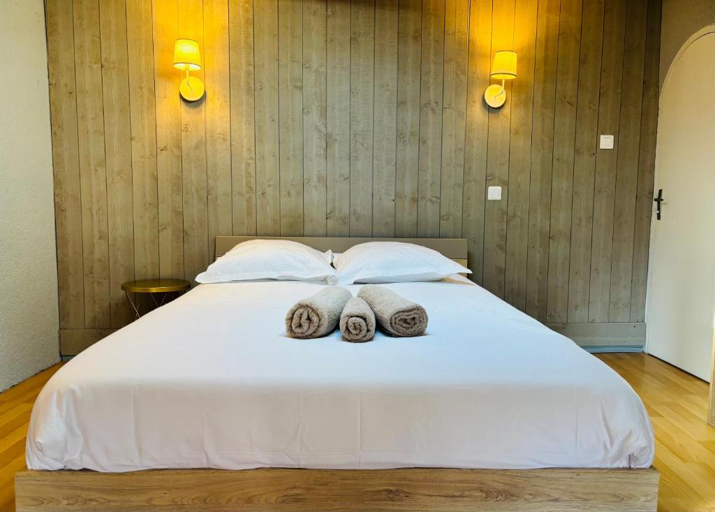a bedroom with a white bed with towels on it at Zen Appartement Centre-ville historique in Niort