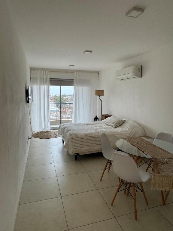 a bedroom with a bed and a table and chairs at Monoambiente in Venado Tuerto