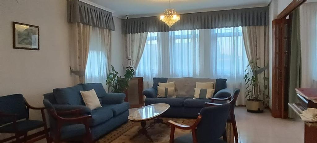 a living room with a blue couch and chairs at Hostal La Madrileña in La Gudiña