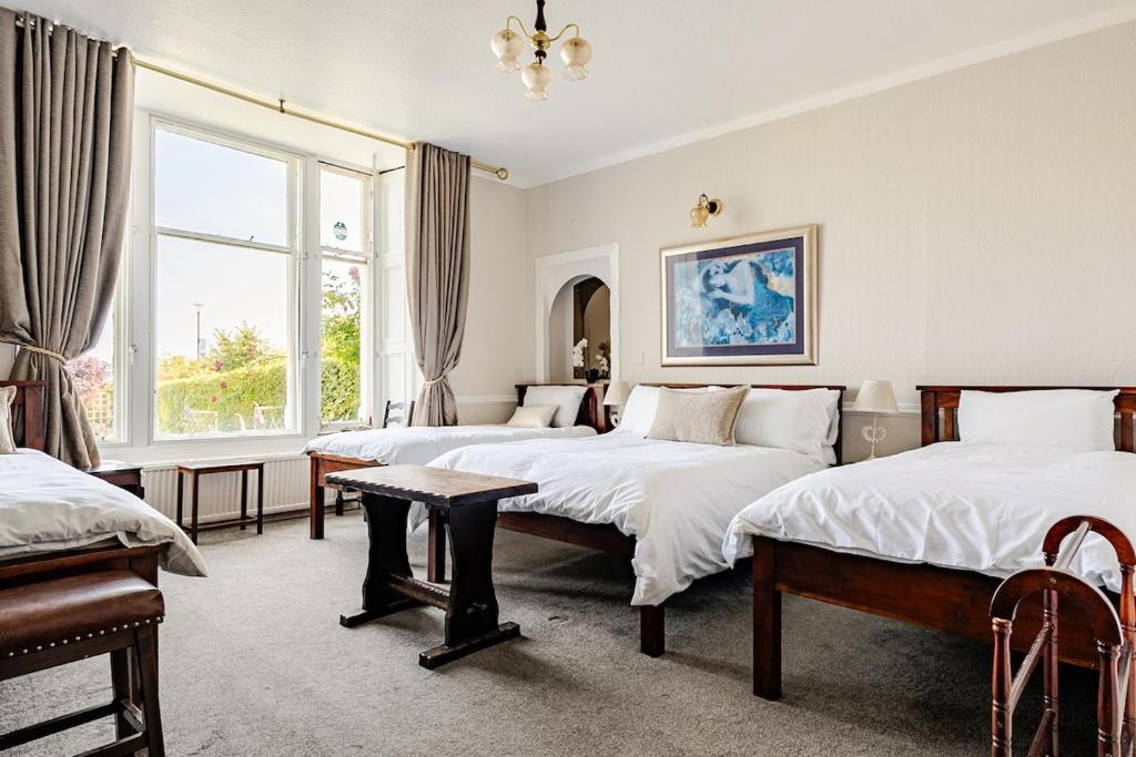 a bedroom with two beds and a table in it at Edinburgh Beach in Edinburgh
