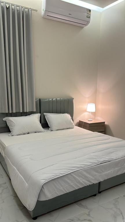 a bedroom with a large bed with white sheets at المجيدل للشقق المفروشة in Arar