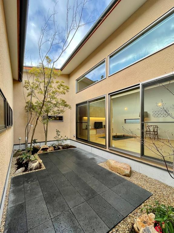 a house with large windows and a patio at ファミリーロッジ つつじ in Sakaiminato