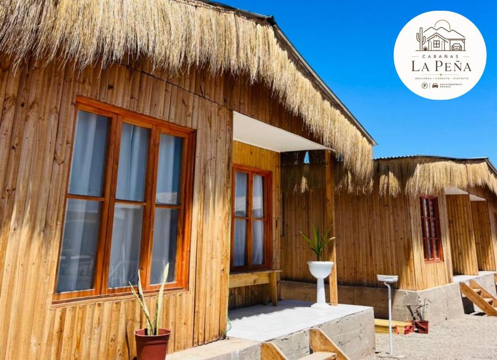 a wooden house with a thatched roof at Cabañas nuevas La Peña in Taltal