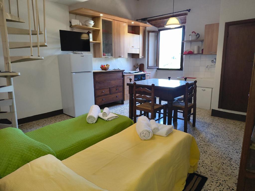 a kitchen with two beds and a table in a room at La casetta del masso in Sorano