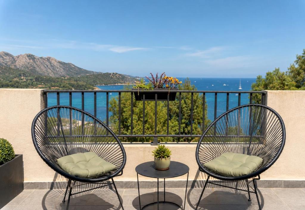 two chairs and a table on a balcony at La Citadelle Appartements in Saint-Florent