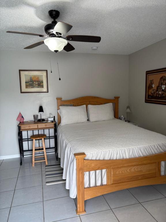 a bedroom with a bed with a ceiling fan and a table at Oasis of the forest in Brandon