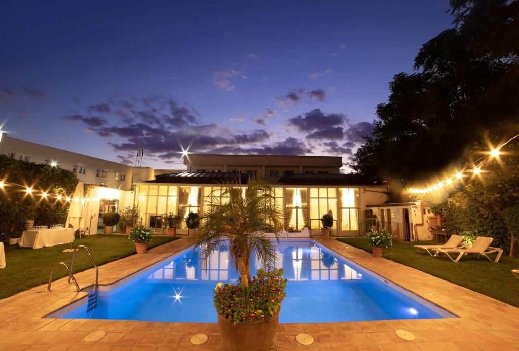 a swimming pool in front of a building at night at Hotel Oasis in Córdoba