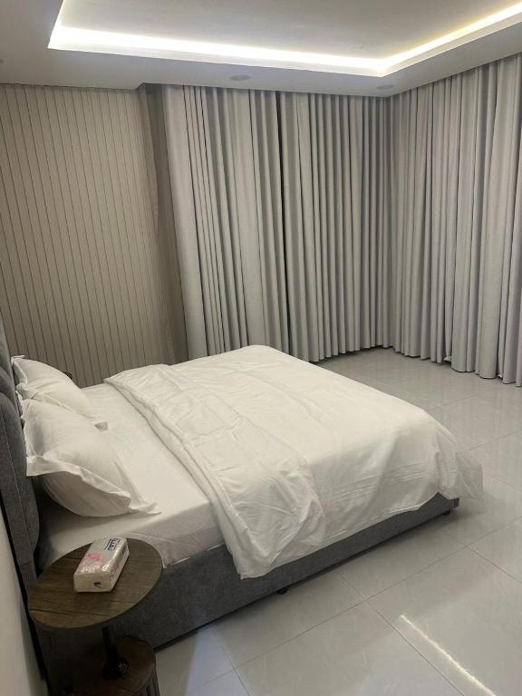 a bedroom with a bed with a phone on a table at شقة غرفتين وصالة in Musaylah