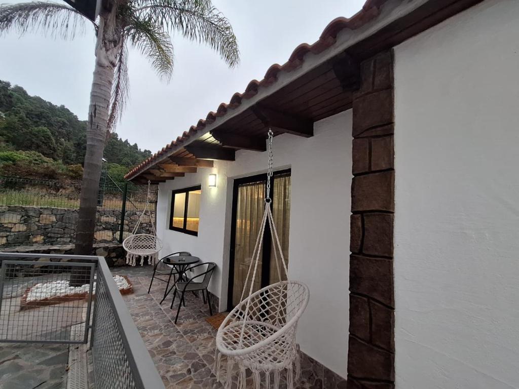 a patio with chairs and a porch with a palm tree at La Campestre in La Guancha