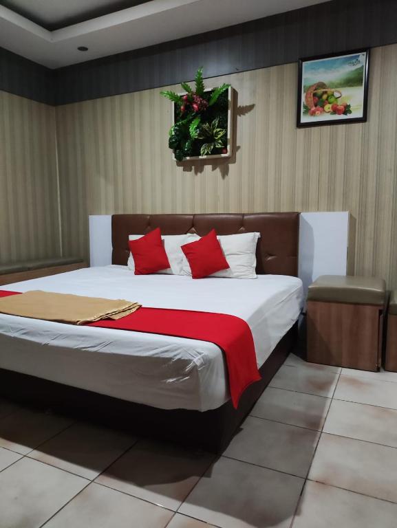 a bedroom with a large bed with red pillows at Angs residence in Surabaya