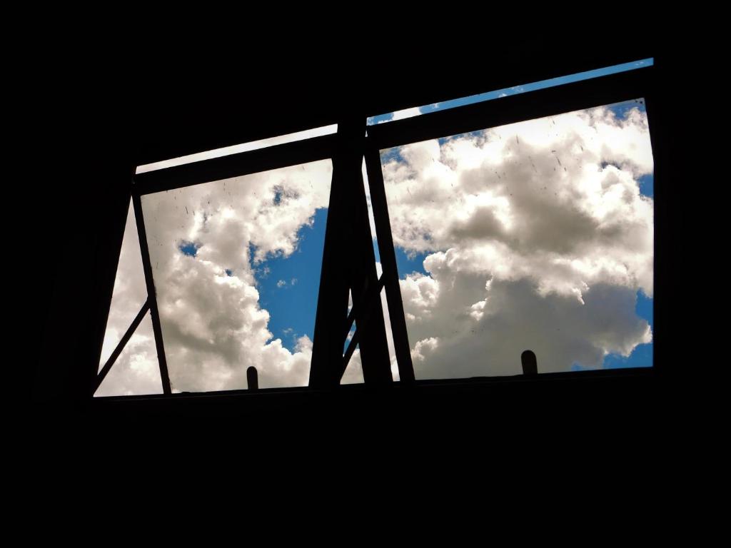 a window with a view of a cloudy sky at Suite na Montanha Magica in São Thomé das Letras