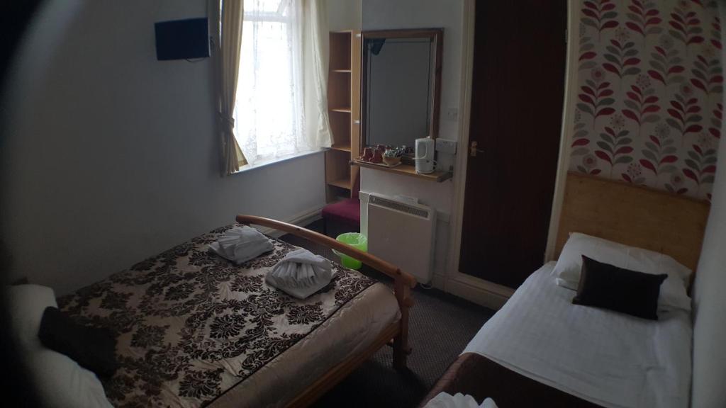 a small bedroom with a bed and a window at The Manuela Rose in Blackpool