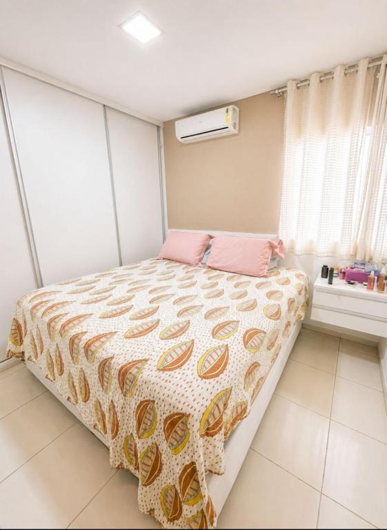 a bedroom with a bed with a pink pillow at Apartamento em Caruaru 3 quartos completo in Caruaru