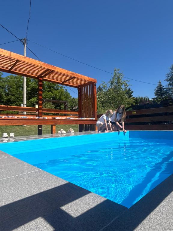 a person jumping into a blue swimming pool at Iskra DDUR in Gornji Milanovac